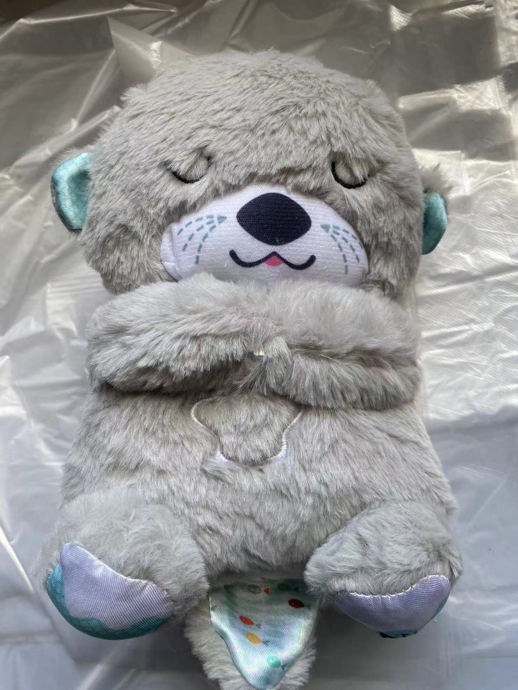 Máquina de sonido Lontra Acurrúcate y Tranquiliza Juguete de peluche portátil para bebé con detalles sensoriales música luces y movimiento rítmico de respiración