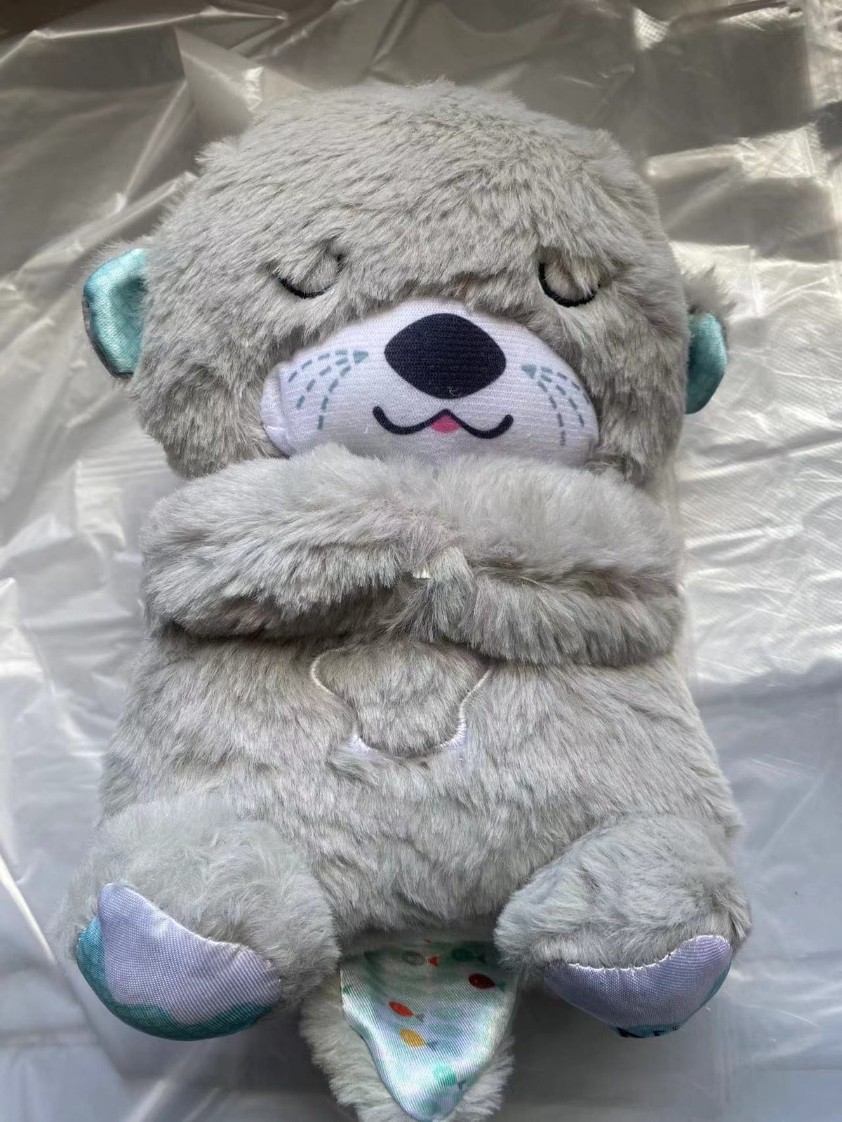 Máquina de sonido Lontra Acurrúcate y Tranquiliza Juguete de peluche portátil para bebé con detalles sensoriales música luces y movimiento rítmico de respiración